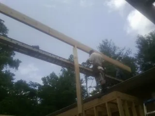 Carpenter setting a ridge beam over a new addition frame — Ice Dam Removal by Roofing Brothers in Rittman