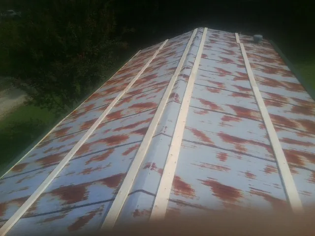 Rusted metal roof panels with new wood purlins before replacement — Storm Damage Roof Repair in Rittman by Roofing Brothers