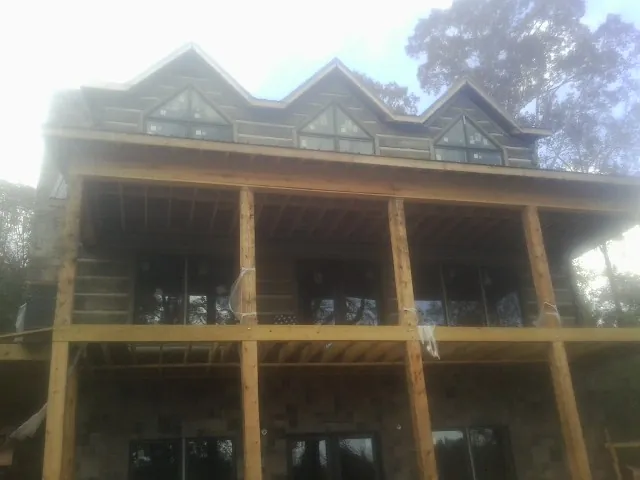 Dormers and porch framing on a large log home under construction — Roof Coating work by our crew in Rittman