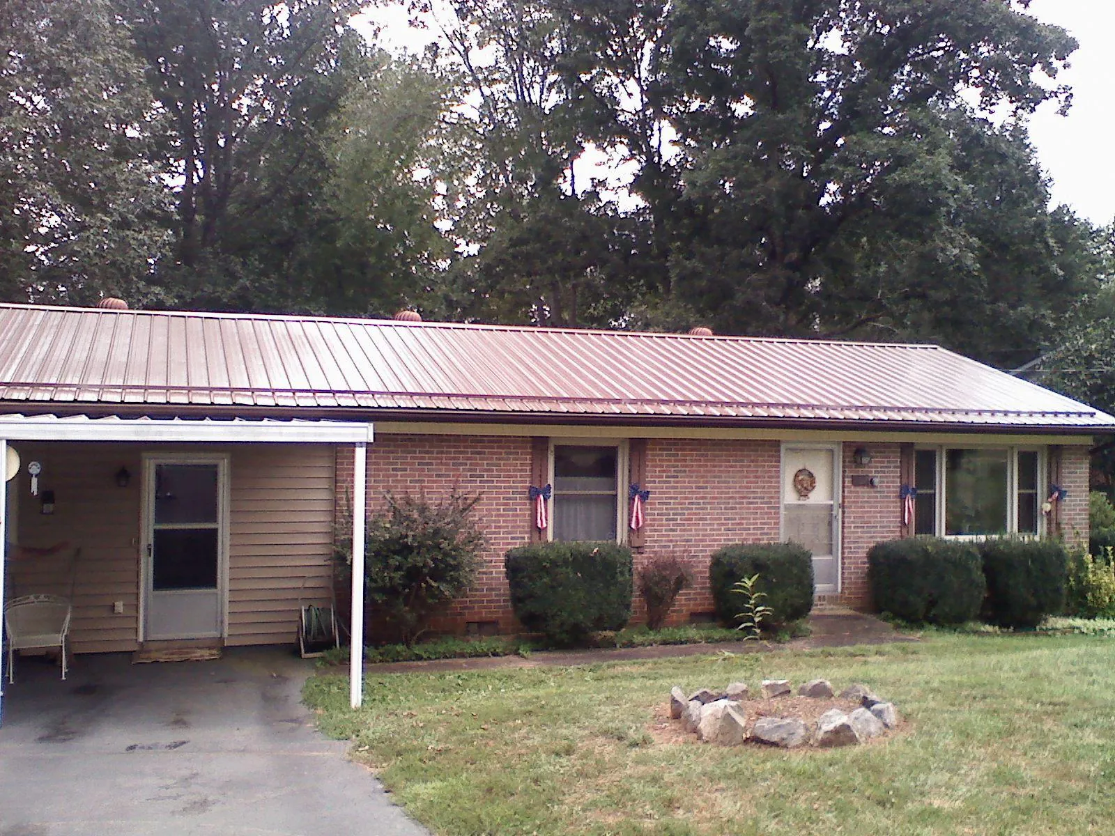 Bronze metal roof and carport on a brick ranch home — Roof Repair work by our crew in Rittman